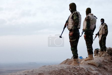 Photo for IRAQ, Gwer: Peshmerga fighters hold a position on the frontline in the Gwer district, 40 kilometres south of Arbil, the capital of the Kurdish autonomous region in northern Iraq, as battles with Islamic State jihadists continue on December 1st, 2015 - Royalty Free Image