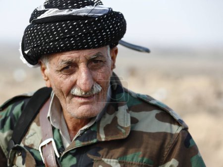 Foto de IRAQ, Gwer: A Peshmerga fighter looks on as he holds a position on the frontline in the Gwer district, 40 kilometres south of Arbil, as battles with Islamic State jihadists continue on December 1st, 2015 - Imagen libre de derechos