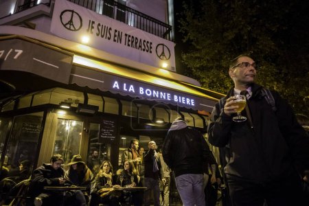Téléchargez les photos : FRANCE, Paris : Des personnes sur la terrasse du bar A la Bonne Biere à Paris le 4 décembre 2015, lors de sa réouverture le lendemain de sa frappe lors d'une série d'attaques coordonnées à Paris et ses alentours le 13 novembre. - en image libre de droit