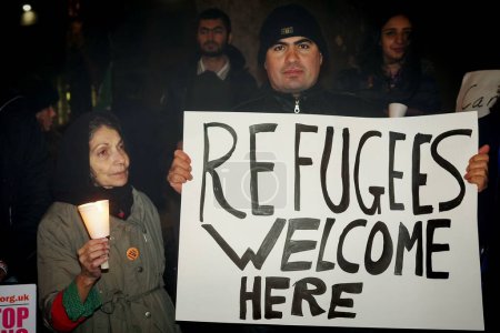 Foto de INGLATERRA, Londres: Personas en apoyo de los refugiados se reunieron en Londres el 12 de diciembre de 2015 para celebrar una vigilia de Navidad en las afueras de Downing Street.. - Imagen libre de derechos