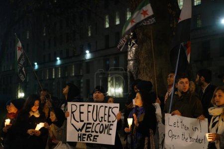 Foto de INGLATERRA, Londres: Personas en apoyo de los refugiados se reunieron en Londres el 12 de diciembre de 2015 para celebrar una vigilia de Navidad en las afueras de Downing Street.. - Imagen libre de derechos
