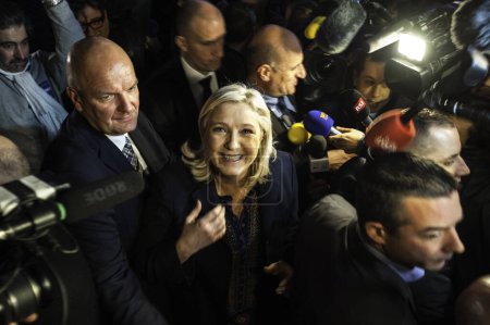 Foto de FRANCIA, Hnin-Beaumont: El líder del Frente Nacional de extrema derecha (FN), Marine Le Pen (C), se marcha después de pronunciar un discurso tras el anuncio de resultados en la segunda vuelta de las elecciones regionales francesas en Henin-Beaumont el 13 de diciembre de 2015. - Imagen libre de derechos