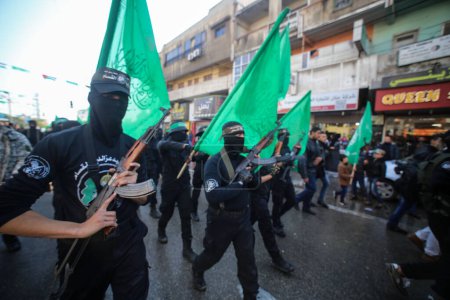 Foto de GAZA, Ciudad de Gaza: Palestinos y militantes de las Brigadas Ezzedine al-Qassam, el brazo armado de Hamás, participan en un mitin con motivo del 28º aniversario de la fundación de Hamás, en la ciudad de Gaza, el 14 de diciembre de 2015 - Imagen libre de derechos