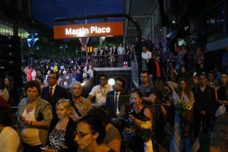 Foto de AUSTRALIA, Sídney: Cientos de personas se reúnen en Martin Place en Sídney el 15 de diciembre de 2015 para conmemorar el primer aniversario del asedio mortal allí. La ceremonia se llevó a cabo en las afueras de la infame Lindt caf donde se llevaron a cabo los rehenes - Imagen libre de derechos