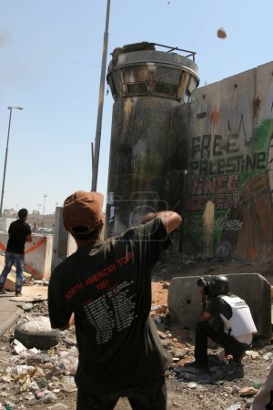 Photo for WEST BANK, Kalandia: Activists from Palestine, Israel and from all over the world throw stones on September 17, 2011 at the Kalandia checkpoint, which is the main corridor between Ramallah and Jerusalem, for the recognition of a state of Palestine - Royalty Free Image