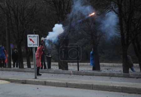 Photo for TURKEY, Ankara: Students throw fireworks towards riot police during the demonstrations at the Middle East Technical University.Students clashed with police in Ankara on December 17, 2015 - Royalty Free Image