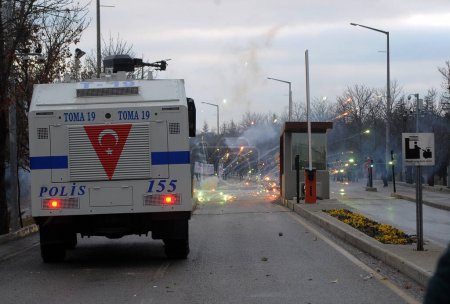 Foto de TURQUÍA, Ankara: Los fuegos artificiales explotan alrededor de un vehículo de seguridad durante las manifestaciones en la Universidad Técnica de Oriente Medio. Los estudiantes se enfrentaron con la policía en Ankara el 17 de diciembre de 2015. - Imagen libre de derechos