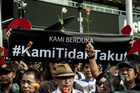 Téléchargez les photos : INDONESIA, Jakarta: People hold up flowers and shout 'we are not afraid' during a rally at the scene of a bombing attack that killed two civilians the day before, in Jakarta, Indonesia, on January 15, 2016. - en image libre de droit