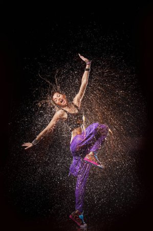 Photo for Woman dancing in rain, Water splash motion - Royalty Free Image