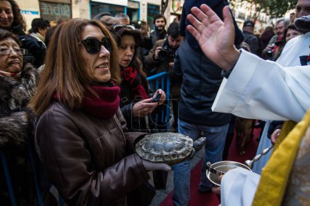 Téléchargez les photos : ESPAGNE, Madrid : Prêtre bénissant les animaux devant l'église de San Antn dans la Calle de Hortaleza à Madrid le jour de la Saint Antoine, le saint patron des animaux, le 17 janvier 2016. - en image libre de droit
