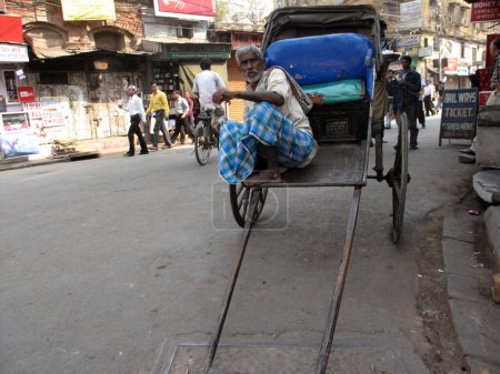 Téléchargez les photos : Rickshaw pilote dans la ville asiatique - en image libre de droit