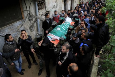 Foto de GAZA STRIP, Ciudad de Gaza: Los dolientes llevan los cuerpos de uno de los siete hombres armados palestinos de Hamás que murieron cuando un túnel se derrumbó cerca de la frontera oriental de la Franja de Gaza con Israel durante su funeral en la Ciudad de Gaza, 29 de enero de 2016 - Imagen libre de derechos