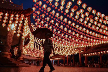 Photo for MALAYSIA, Kuala Lumpur: A man stands under hundreds of red lanterns at the the temple in Kuala Lumpur, in Malaysia, on February 06, 2016. - Royalty Free Image