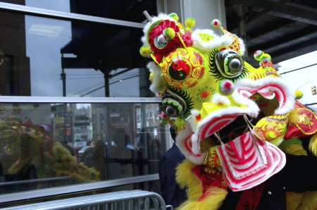 Téléchargez les photos : États-Unis, New York : Un homme revêt un costume de dragon alors que les fêtards défilent dans une neige légère le 8 février 2016 pour célébrer le Nouvel An lunaire. - en image libre de droit