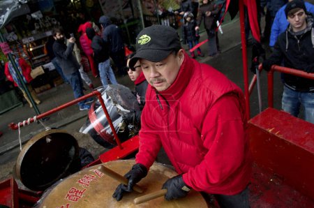 Téléchargez les photos : États-Unis, New York : Un homme joue du tambour alors qu'il marche avec d'autres fêtards à travers le quartier chinois de New York le 8 février 2016 pour célébrer le Nouvel An lunaire - en image libre de droit