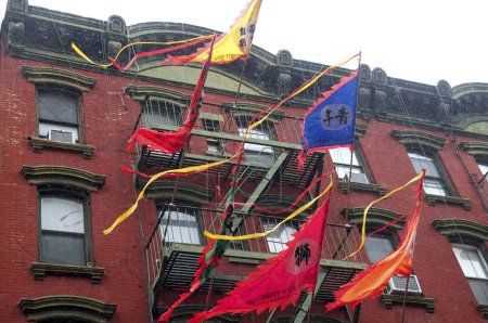 Téléchargez les photos : États-Unis, New York : Des drapeaux flottent dans le quartier chinois de New York alors que les fêtards dansent avec des dragons et marchent dans une neige légère le 8 février 2016 pour célébrer le Nouvel An lunaire. - en image libre de droit