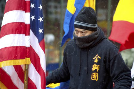 Foto de EE.UU., Nueva York: Un hombre marcha a través de una nieve ligera con otros juerguistas en Chinatown de la ciudad de Nueva York el 8 de febrero de 2016 en celebración del Año Nuevo Lunar. - Imagen libre de derechos