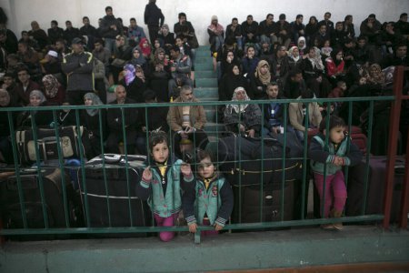 Foto de GAZA STRIP, Rafah: Los palestinos esperan permiso para entrar en Egipto mientras se reúnen en el cruce fronterizo de Rafah en el sur de la Franja de Gaza el 14 de febrero de 2016. - Imagen libre de derechos