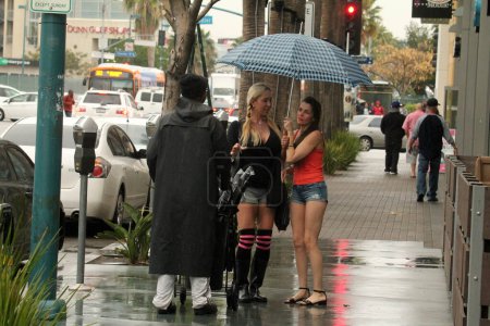Téléchargez les photos : Alicia Arden, Mary Carey les stars "" Celebrity Rehab "" et "" Hoarding : Buried Alive "" portent ensemble des shorts coupés Daisy Duke, pris dans une pluie inattendue, essayant de trouver un unbrella dans la voiture d'Alicia, North Hollywood, CA - en image libre de droit