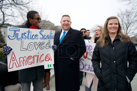 Téléchargez les photos : Etats-Unis, Washington DC : Les fans sourient alors que des milliers de personnes attendent de rendre hommage au juge Antonin Scalia de la Cour suprême, qui repose au plus haut tribunal de la nation à Washington DC le 19 février 2016 - en image libre de droit