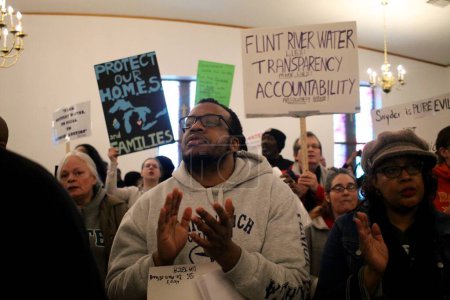 Photo for USA, Flint: Residents of Flint, Michigan cheer during a rally for clean water at the Metropolitan Baptist Church on February 19, 2016. - Royalty Free Image