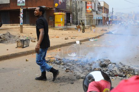 Foto de UGANDA, Kampala: Los escombros arden en medio de los disturbios en Kampala, Uganda, después del arresto del candidato presidencial Kiiza Besigye y sus partidarios en la sede de su partido el 19 de febrero de 2016. - Imagen libre de derechos
