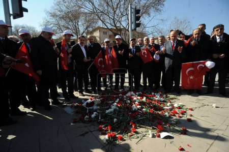 Téléchargez les photos : TURQUIE, Ankara : Des gens pleurent près des oeillets posés sur la rue Merasim à Ankara, le 22 février 2016 près du site de l'attentat à la voiture piégée qui a tué 28 personnes, y compris des civils et des membres des forces de sécurité, le 17 février. - en image libre de droit