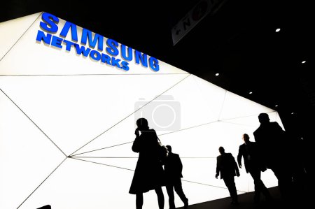 Foto de ESPAÑA, Barcelona: Se ve a los visitantes caminando frente al stand de Samsung Networks durante el Mobile World Congress, en Barcelona, el 22 de febrero de 2016. - Imagen libre de derechos