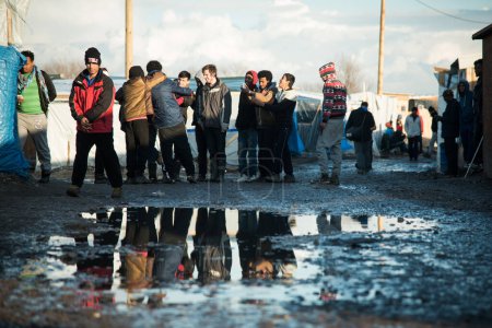Foto de FRANCIA, Calais: Empleados de la prefectura de Calais y voluntarios son vistos en el campamento de migrantes de la Selva de Calais, al norte de Francia, el 26 de febrero de 2016, mientras informan a los migrantes sobre la orden de desalojo - Imagen libre de derechos