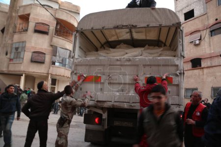 Téléchargez les photos : SYRIE, Kafr Batna : Le personnel du Croissant-Rouge syrien enquête sur la livraison de l'aide humanitaire dans un entrepôt à Kafr Batna, dans la région de Ghouta orientale, dans le sud de la Syrie, aux abords de la capitale Damas, le 23 février 2016 - en image libre de droit