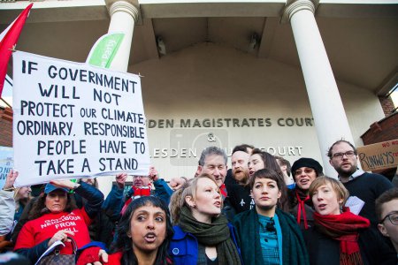 Téléchargez les photos : ROYAUME-UNI, Londres : Des membres du groupe "Plane Stupid" s'adressent aux manifestants alors que ceux-ci se réunissent à la cour des magistrats de Willesden le 24 février 2016 à Londres - en image libre de droit