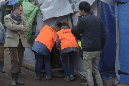Téléchargez les photos : FRANCE, Calais : Des employés de la préfecture de Calais et des bénévoles sont vus dans le camp de migrants de la jungle de Calais, dans le nord de la France, le 26 février 2016, alors qu'ils informent les migrants de l'ordre d'expulsion - en image libre de droit