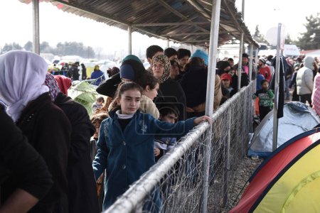 Photo for Greece, Idomeni - March 05, 2016: People queue for food at a refugee camp at the Greek-Macedonia border - Royalty Free Image