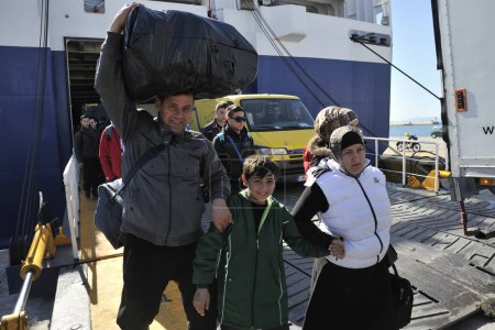 Téléchargez les photos : GRÈCE, Pirée : Des familles de réfugiés arrivent au port du Pirée après avoir voyagé à bord d'un navire nommé Diagoras de la compagnie Blue Star Ferries au début du 3 mars 2016 en provenance des îles de la mer Égée. 580 migrants et réfugiés sont arrivés le 3 mars 2016 - en image libre de droit