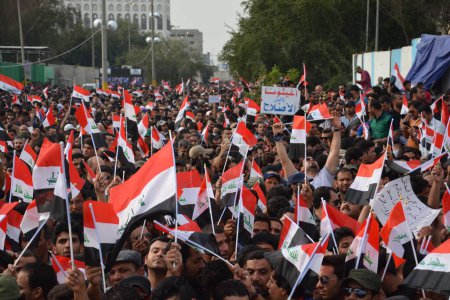 Téléchargez les photos : IRAQ, Bagdad : Des dizaines de milliers de personnes ont défilé à Bagdad le 4 mars 2016, en soutien au religieux chiite irakien Muqtada al-Sadr, agitant des drapeaux nationaux et criant des slogans lors d'un rassemblement pour les réformes gouvernementales et contre la corruption - en image libre de droit
