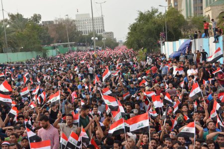Téléchargez les photos : IRAQ, Bagdad : Des dizaines de milliers de personnes ont défilé à Bagdad le 4 mars 2016, en soutien au religieux chiite irakien Muqtada al-Sadr, agitant des drapeaux nationaux et criant des slogans lors d'un rassemblement pour les réformes gouvernementales et contre la corruption - en image libre de droit
