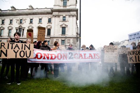 Téléchargez les photos : ANGLETERRE, Londres : Des manifestants défilent avec des banderoles lors d'une manifestation à Londres le 5 mars 2016, contre la fermeture des frontières et la violence envers les réfugiés au camp de Calais - en image libre de droit