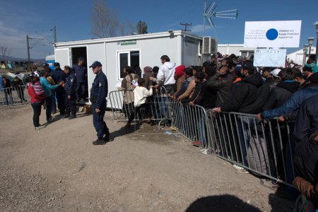 Foto de Grecia, Idomeni - 05 de marzo de 2016: La gente hace cola para comer en un campo de refugiados en la frontera entre Grecia y Macedonia - Imagen libre de derechos