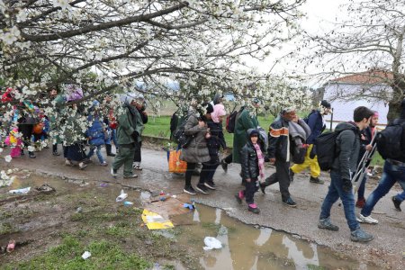 Téléchargez les photos : Grèce, Idomeni - 14 mars 2016 : Des migrants et des réfugiés traversent une rivière qui monte en flèche en route vers la Macédoine depuis un camp de fortune à la frontière gréco-macédonienne, près du village grec d'Idomeni - en image libre de droit