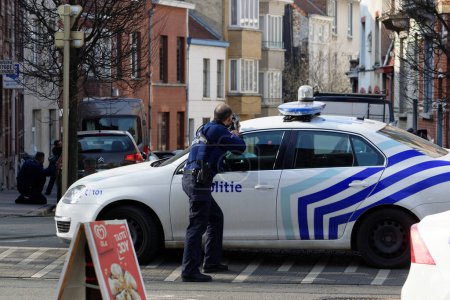 Foto de BÉLGICA, Bruselas: Oficiales de policía intervienen en el lugar de un tiroteo en Dries-Driesstraat en Forest-Vorst, Bruselas, el 15 de marzo de 2016. - Imagen libre de derechos
