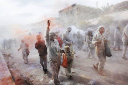 Photo for GREECE, Galaxidi: People hold hands and light smoke canisters as part of the annual flour battle on March 14, 2016 - Royalty Free Image