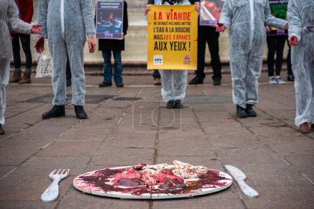 Foto de FRANCIA, París: Miembros de la asociación Vegan Impact posan con las manos ensangrentadas, durante una manifestación conmemorativa del Día Internacional sin Carne, en la plaza Saint-Michel de París, el 19 de marzo de 2016. - Imagen libre de derechos