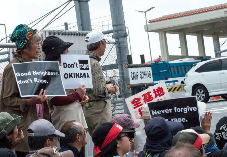 Foto de JAPÓN, Okinawa: Mientras los manifestantes se sientan a lo largo de la puerta del Campamento Schwab, un vehículo militar entra por la puerta de Okinawa, Japón, el 21 de marzo de 2016 - Imagen libre de derechos
