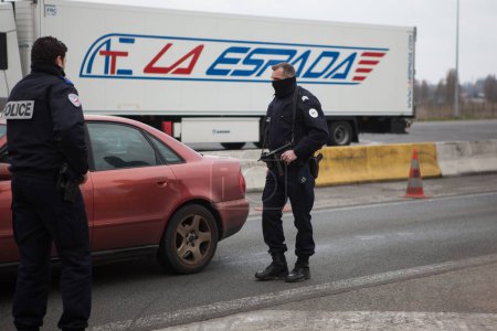 Téléchargez les photos : FRANCE, Neuville-en-Ferrain : Des policiers français vérifient des véhicules à la frontière franco-belge, près de Neuville-en-Ferrain, dans le nord de la France, le 22 mars 2016 - en image libre de droit