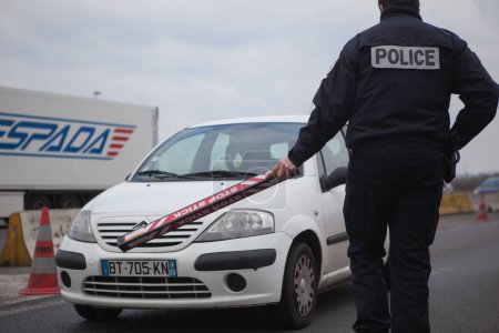 Téléchargez les photos : FRANCE, Neuville-en-Ferrain : Des policiers français vérifient des véhicules à la frontière franco-belge, près de Neuville-en-Ferrain, dans le nord de la France, le 22 mars 2016 - en image libre de droit