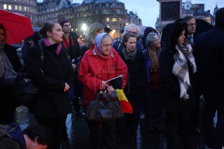 Téléchargez les photos : UNITED KINGDOM, London : People stand near lit candles and a giant Belgian flag during a tribute to the victims of the Brussels terror attacks, outside if The Naional Gallery in Trafalgar Square in central London on March 24, 2016 - en image libre de droit