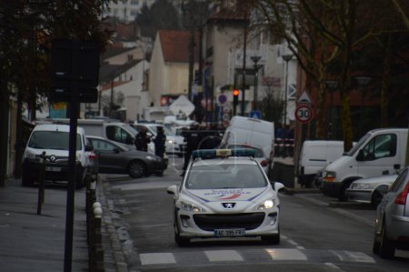Foto de FRANCIA, Argenteuil: Oficiales de policía caminan en una calle después de una redada en el barrio Argenteuil al noroeste de París el 25 de marzo de 2016. El ministro del Interior francés Bernard Cazeneuve dijo que la policía había arrestado a un sospechoso en el área de París - Imagen libre de derechos