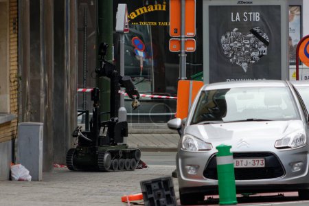 Photo for BELGIUM, Brussels: Police, military and bomb squad secure the area around Vanderkindere street as a SEDEE bomb disposal robot is at work in Uccle district, southern Brussels on March 26, 2016 - Royalty Free Image