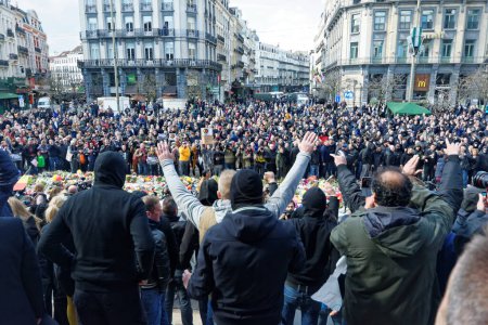 Téléchargez les photos : BELGIQUE, Bruxelles : Des hooligans d'extrême droite chantent des slogans devant la bourse de Bruxelles le 27 mars 2016 - en image libre de droit
