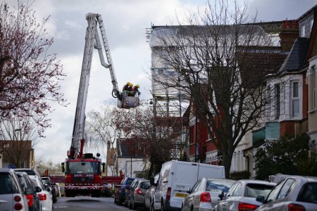 Foto de REINO UNIDO, Londres: Los bomberos intentan asegurar un andamiaje que en parte se derrumbó en una tormenta de agua de la casa Katie golpea la zona, en Lealand Road, en el barrio de Tottenham, al norte de Londres, el 28 de marzo de 2016. - Imagen libre de derechos